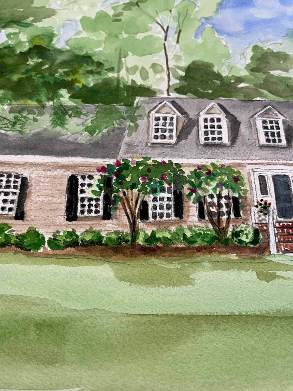 Watercolor painting of a house with a garden and trees