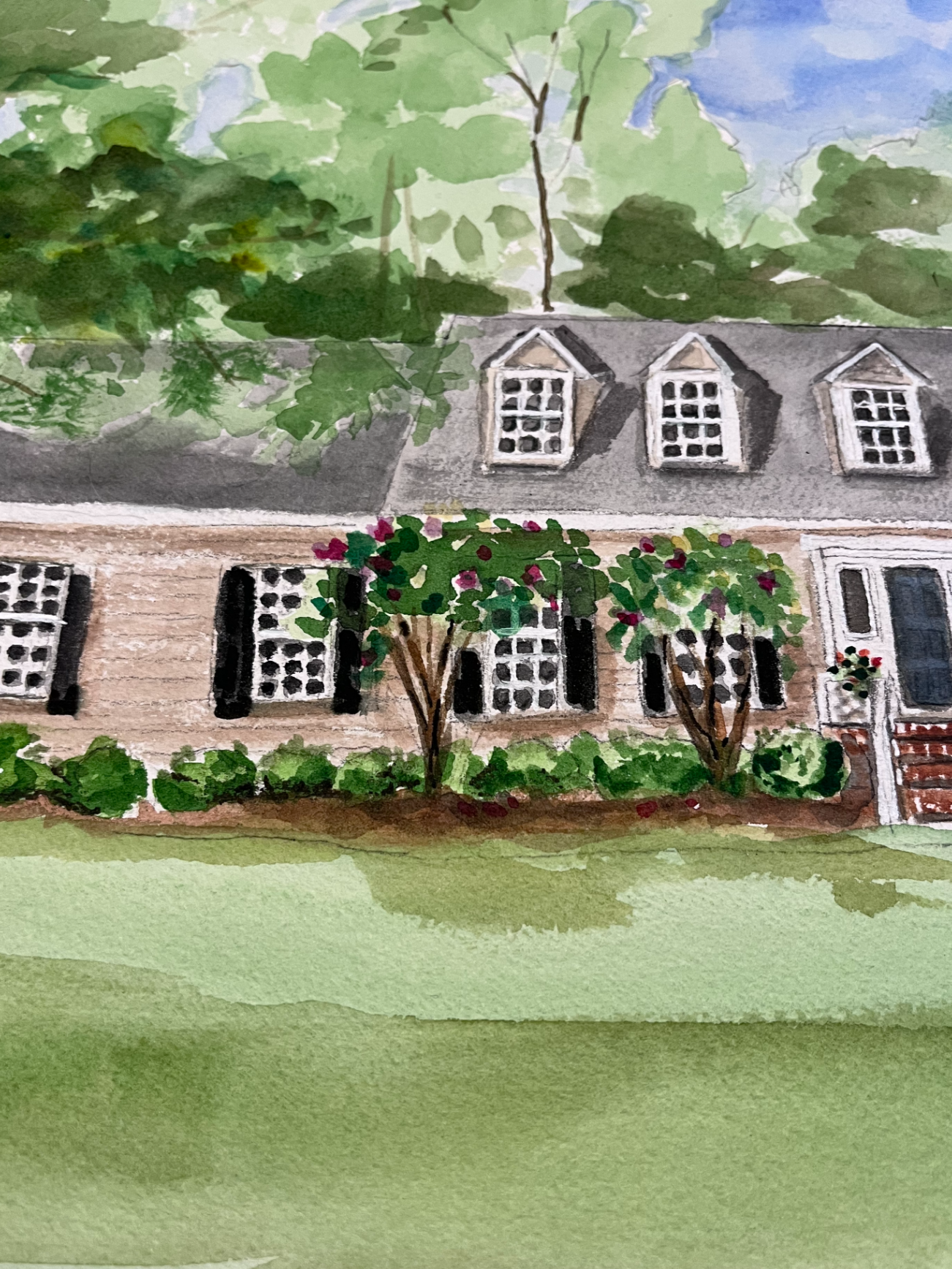 Watercolor painting of a house with a garden and trees