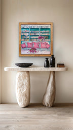 Stylish interior with a stone console table, decorative items, and a framed painting on a beige wall.